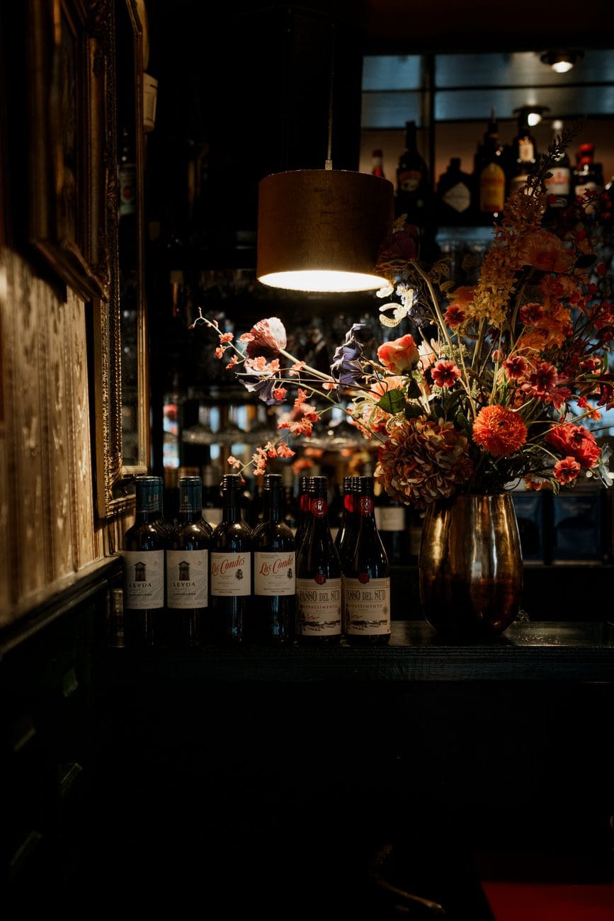 De bar met een boeket en de flessenwand erachter