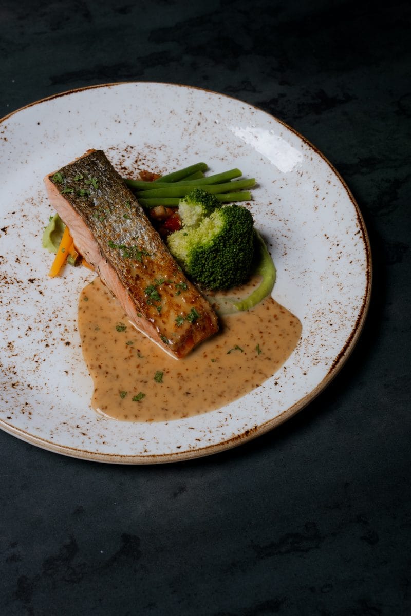 Zalmfilet met groene groenten en een romige saus