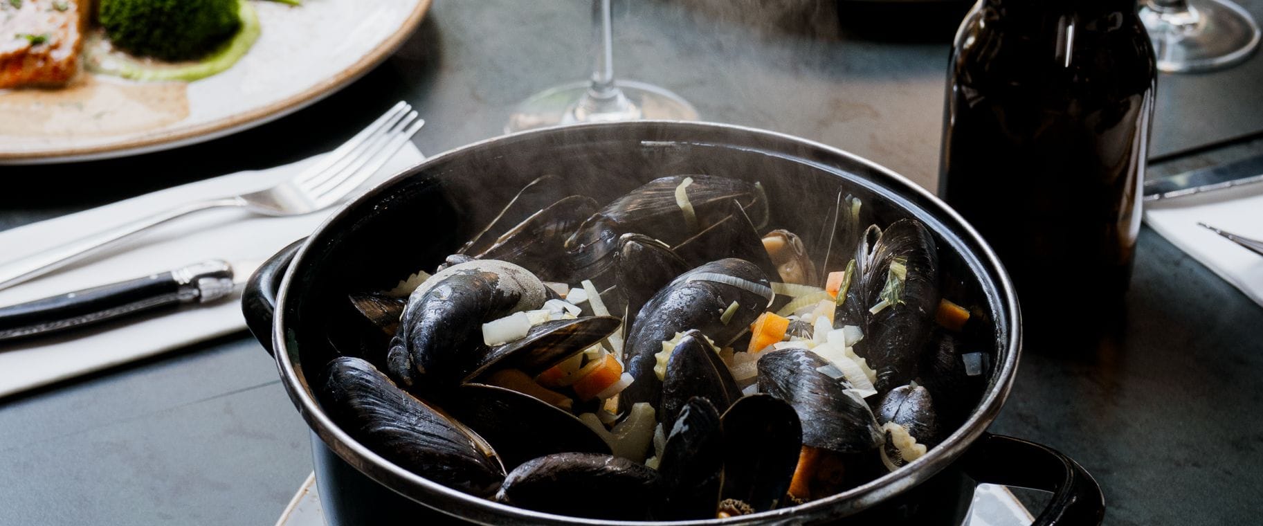 De mosselpan staat te stomen op tafel